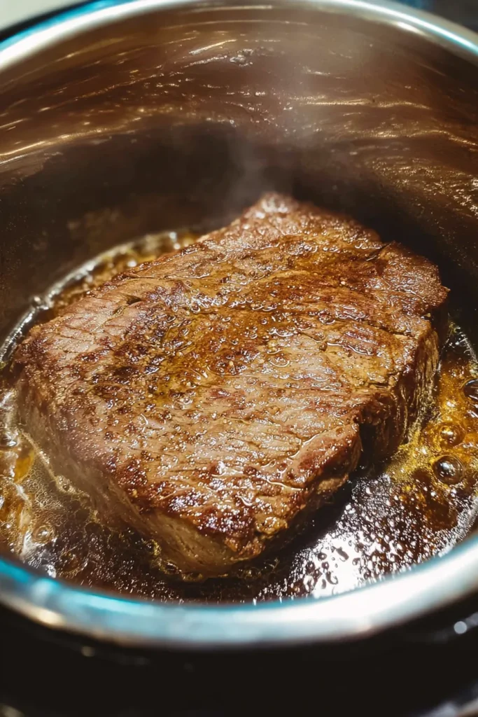 Searing a London broil steak inside an Instant Pot with golden crust under natural daylight in a bright white kitchen